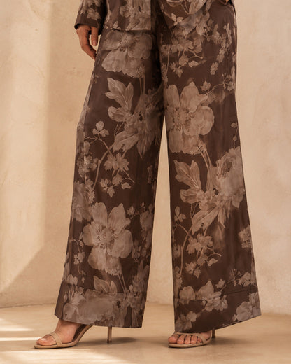 Close-up of Sahara Bloom bronze wide-leg silk trousers showing the contrasting light floral pattern.