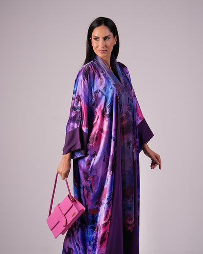 Front view showing the abaya’s colourful print and plain violet sleeve cuffs.