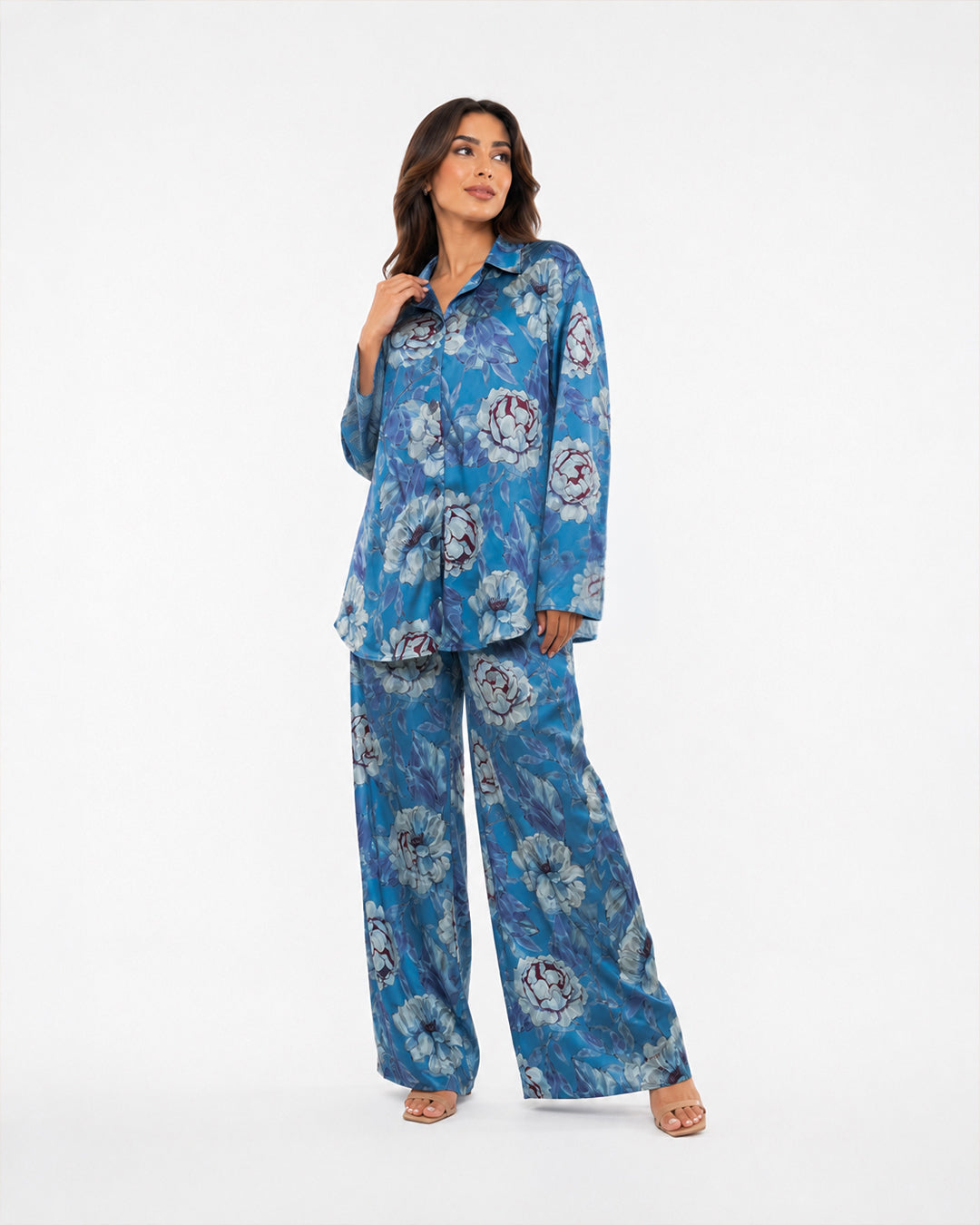 Studio view of the Sahara Bloom blue silk two-piece set showing its relaxed long-sleeve shirt and matching floral trousers.