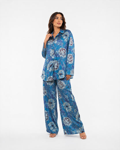 Studio view of the Sahara Bloom blue silk two-piece set showing its relaxed long-sleeve shirt and matching floral trousers.