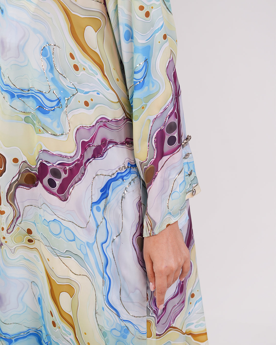 Close-up of the Lagoon Azure silk dress’s patterned sleeve and fabric detail.