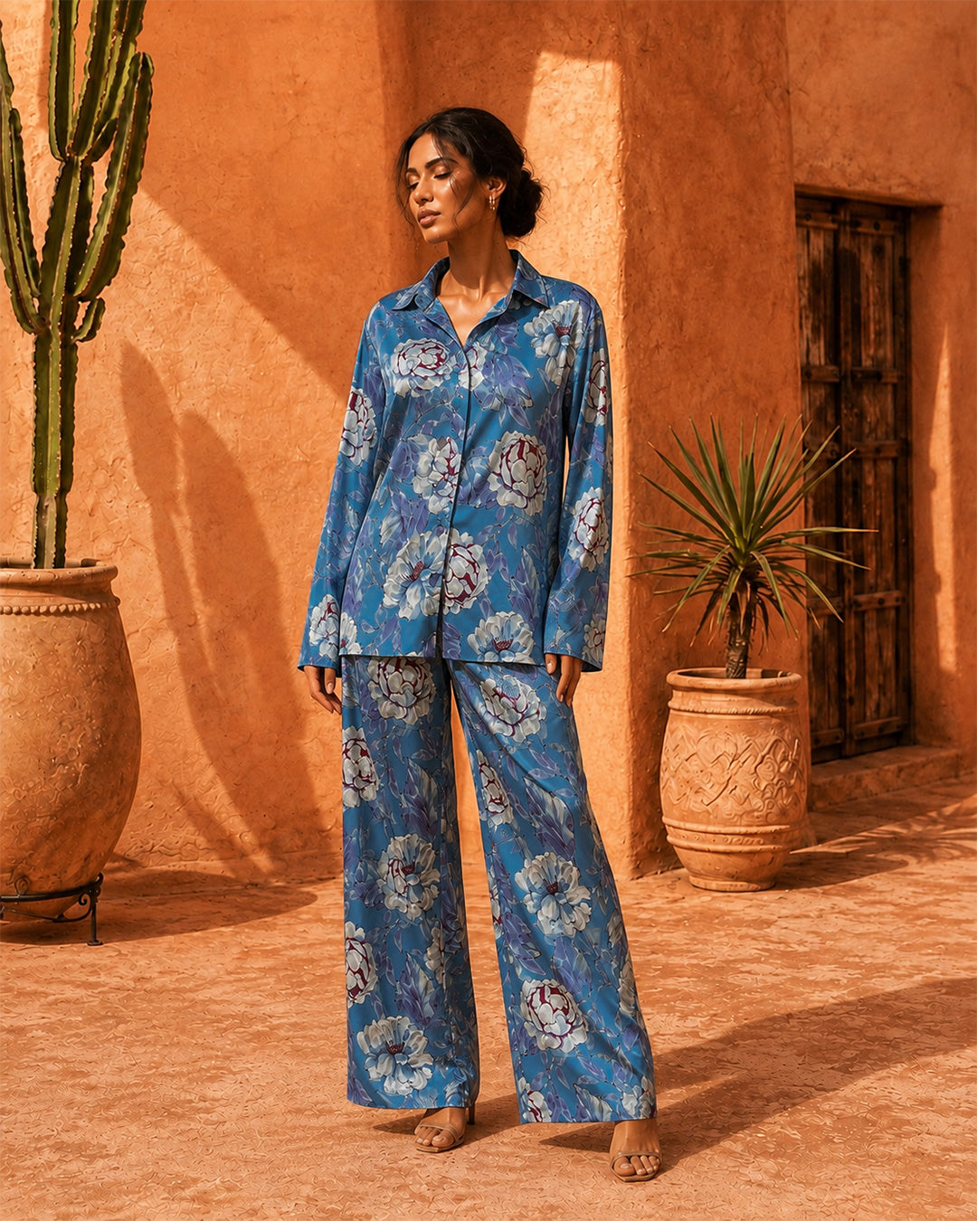 Model wearing the Sahara Bloom blue floral silk co-ord set with a collared shirt and wide-leg trousers.