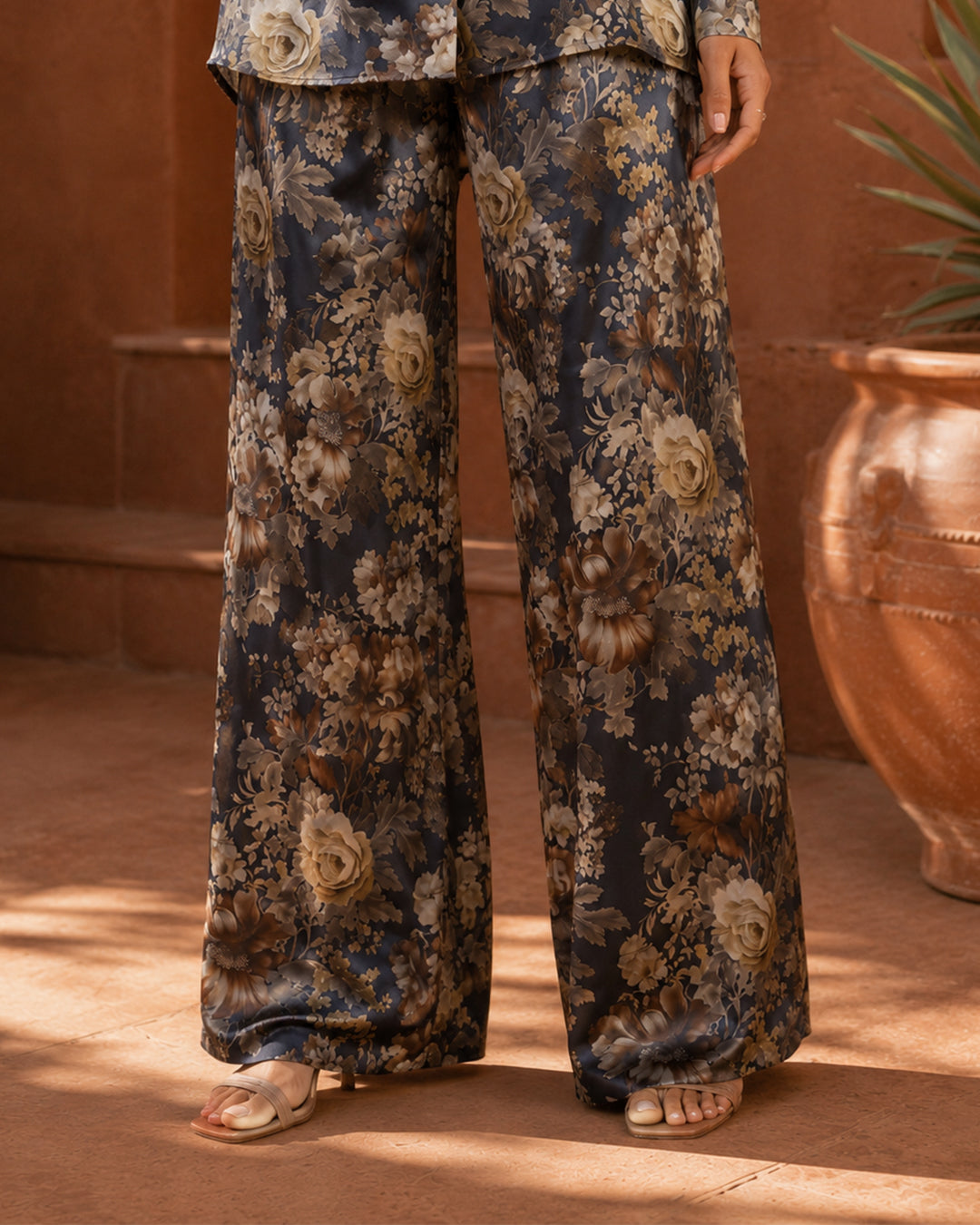 Close-up of Sahara Bloom midnight navy wide-leg silk trousers with a beige and cream floral print.