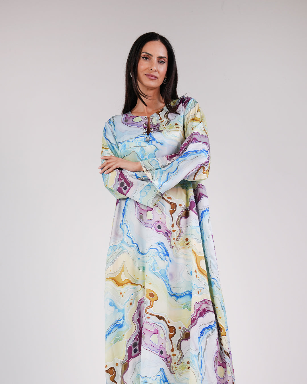 Model wearing the Lagoon Azure silk dress with a flowing blue, turquoise and lime print.