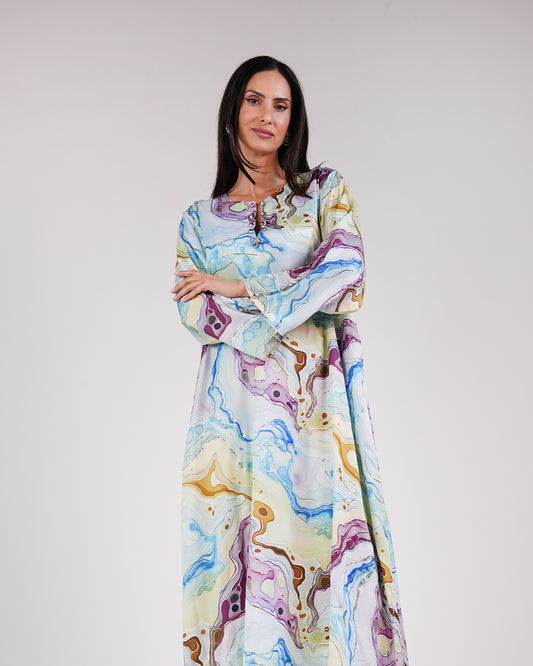 Model wearing the Lagoon Azure silk dress with a flowing blue, turquoise and lime print.
